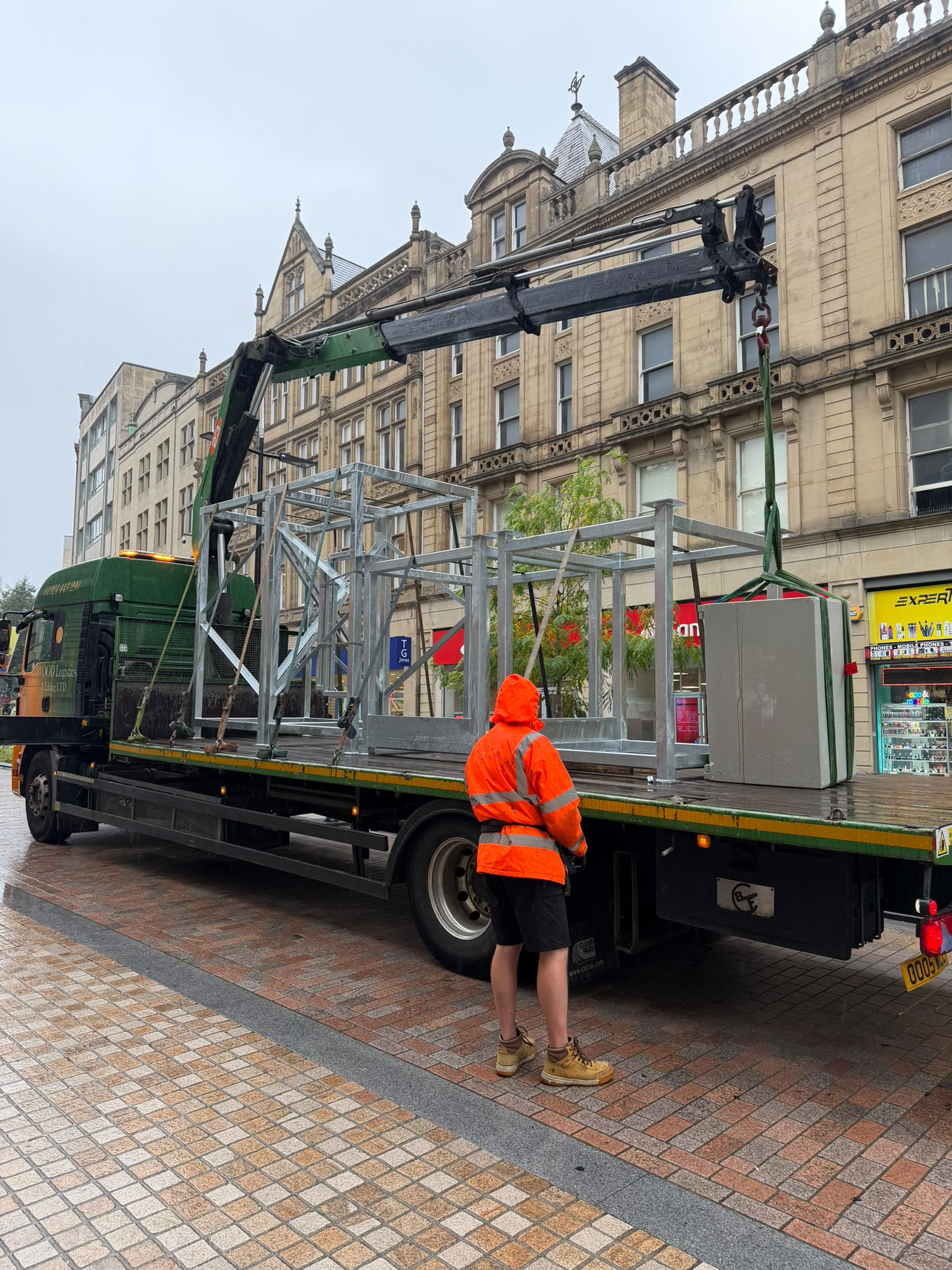 A safe being moved using specialist lifting equipment outside a commercial building