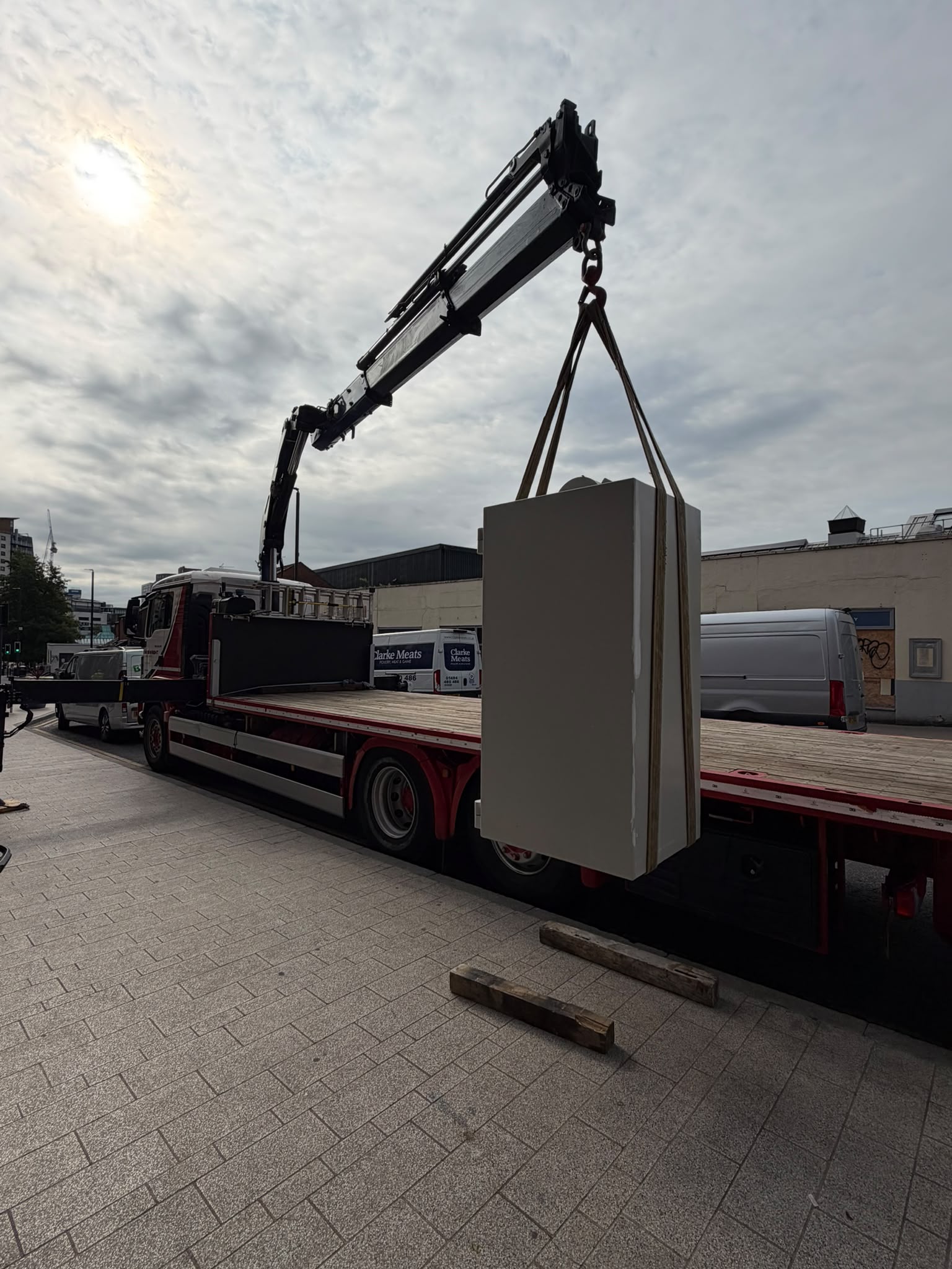 A large safe being lifted with a vehicle-mounted crane