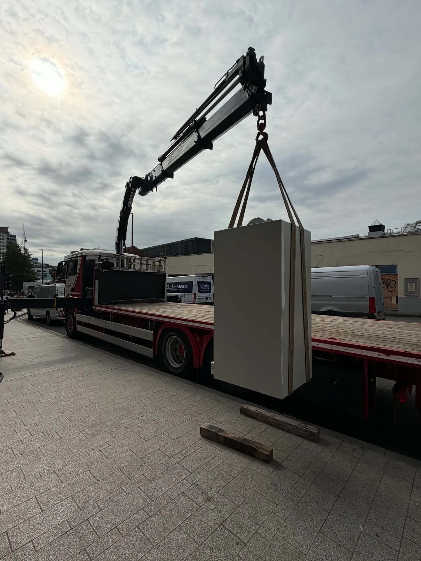 A large safe being lifted onto a specialist transport vehicle